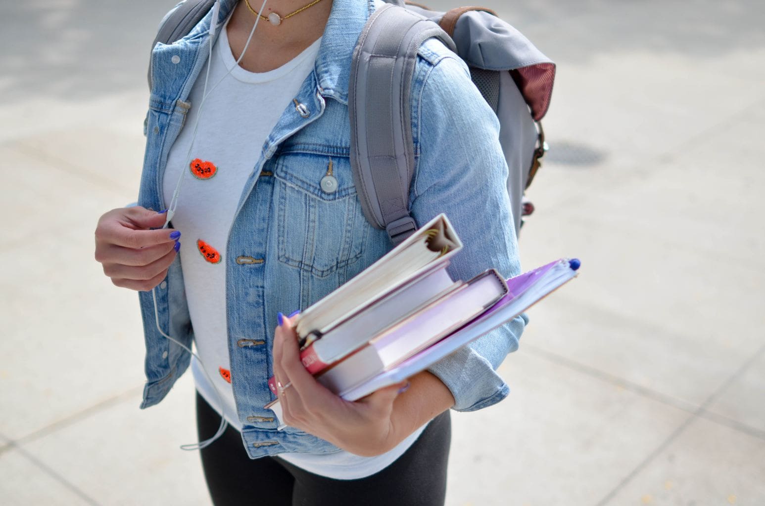 college girl with backpack carrying books